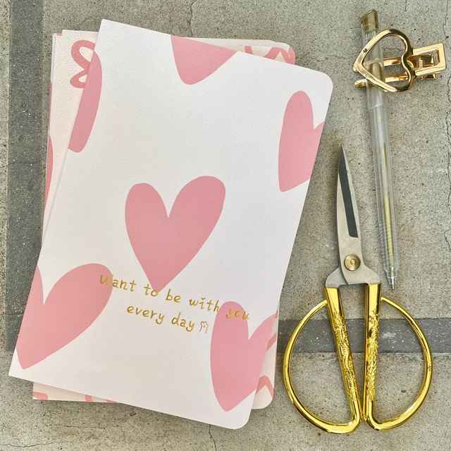 Cuaderno M con diseño de corazones grandes