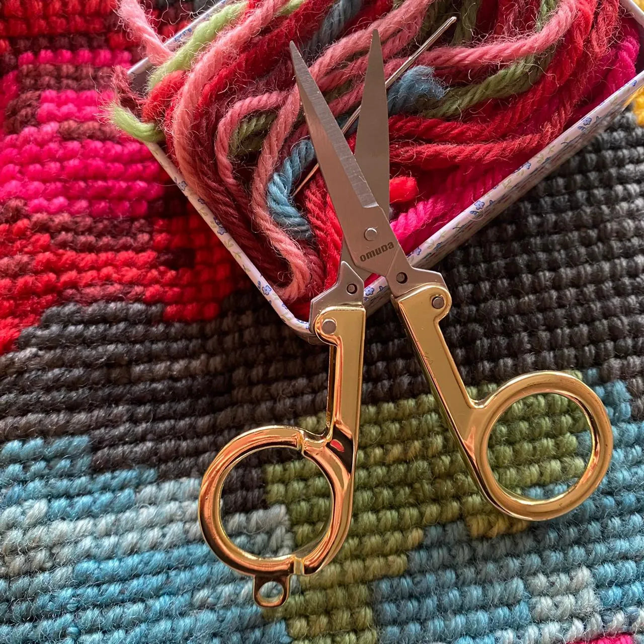 Tijera plegable con mango dorado
