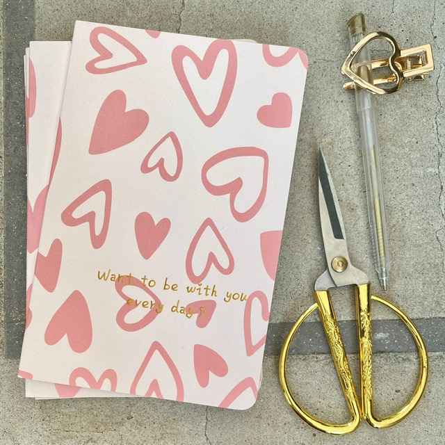 Cuaderno M con diseño de corazones mixtos